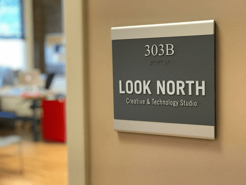 A photograph of the Look North sign which also contains the company name in braille